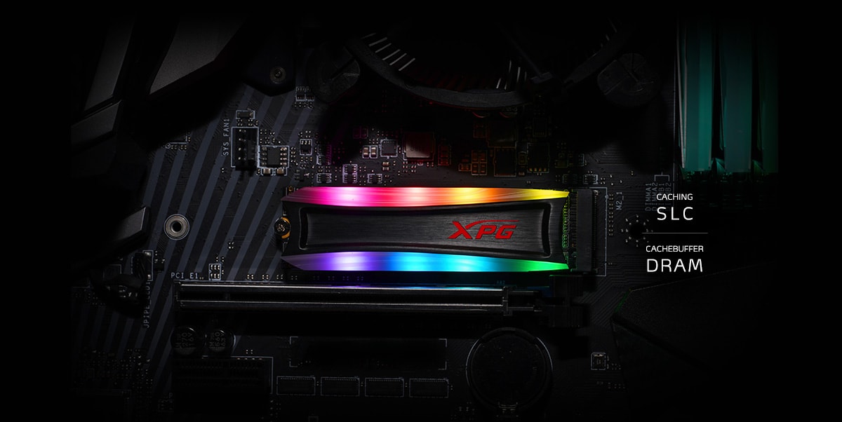 A SPECTRIX S40G installed on the motherboard, with RGB lighting turned on. Texts on the right reads Caching SLC on the top layer, and Cachebuffer DRAM on the bottom layer.